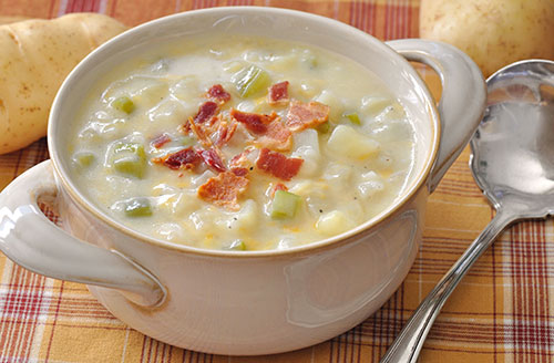 bacon bits on potato soup in white bowl