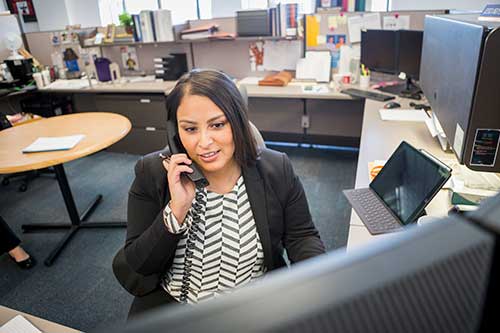 person talking on the phone at a computer