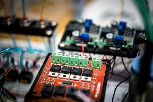 orange circuit board wired to another circuit board