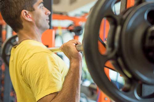 person lifting a barbell at chest level