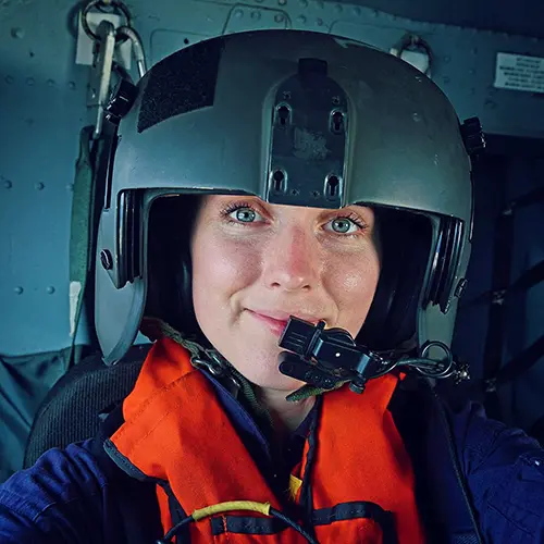 Steenson in a black helicopter helmet with a microphone over her mouth